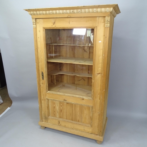 2066 - A pine display cabinet, with single glazed door and applied carved decoration, 111cm x 175cm x 57cm