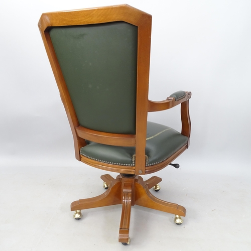 2070 - A green studded leather upholstered swivel desk chair