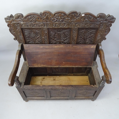 2099 - An Antique carved oak hall settle, with panelled back and lifting seat, inscribed 1697, 110cm x 120c... 