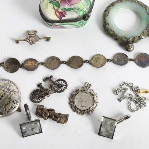 1065 - A jade and white metal mounted pendant, a floral and enamel buckle, three penny bit coin bracelet et... 