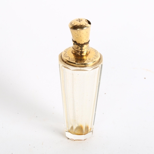 1084 - A faceted glass scent bottle, with an engraved unmarked yellow metal mount