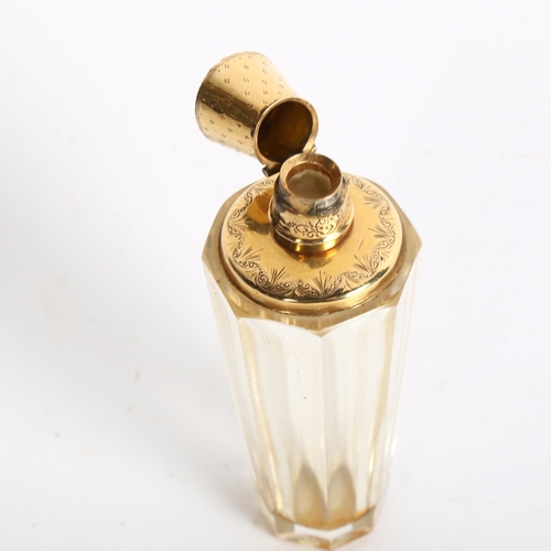 1084 - A faceted glass scent bottle, with an engraved unmarked yellow metal mount