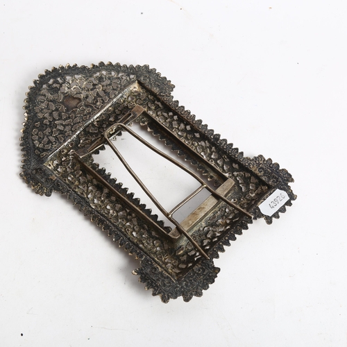 1094 - An Eastern white metal photograph frame, with allover scrolled pierced and embossed decoration