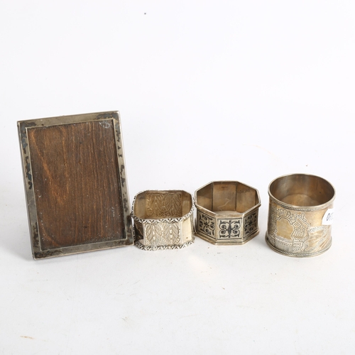 1112 - 3 decorative silver napkin rings, and a small rectangular silver-fronted photo frame (4)