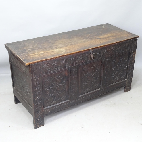 2230 - An 18th century joined oak coffer, with plain plank top, relief carved panelled front, on stile legs... 