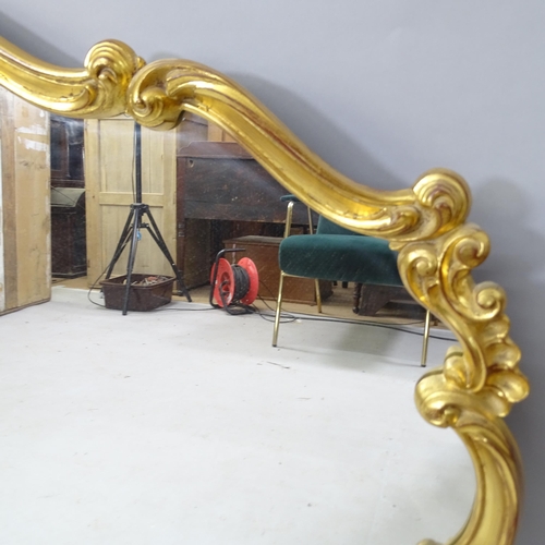 2315 - A modern gilt painted wall mirror of shaped form, 118cm x 90cm