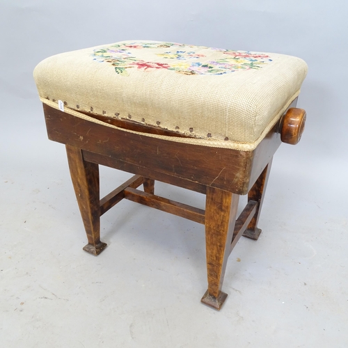 2603 - An Arts and Crafts mahogany rise and fall piano stool, with embroidered seat, on square tapered legs... 