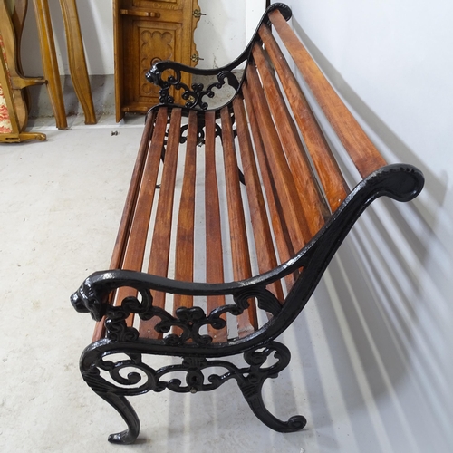 2662 - A stained teak slatted garden bench, with cast-iron ends, L123cm