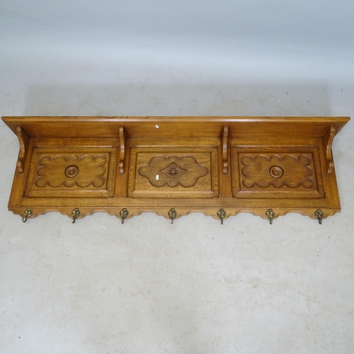 A 1930s carved and panelled oak hat and coat rack, length 172cm