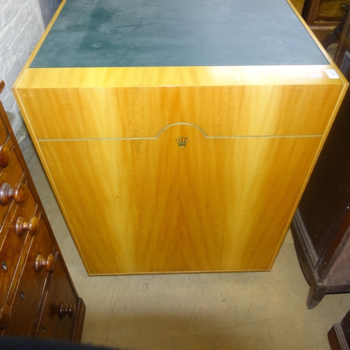 2015 - A contemporary teak kneehole writing desk, with label for Rolex, having inlaid green leather skiver ... 