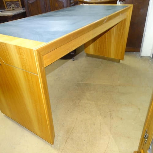 2015 - A contemporary teak kneehole writing desk, with label for Rolex, having inlaid green leather skiver ... 