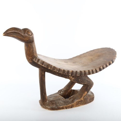 1061 - An African Tribal stool in the form of a bird, carved from a single piece of wood, length 62cm