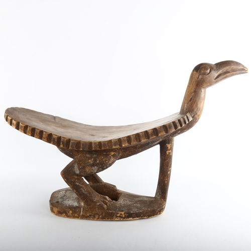 1061 - An African Tribal stool in the form of a bird, carved from a single piece of wood, length 62cm