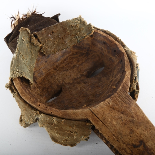 1062 - An African carved wood Tribal mask, with textile and shell surround and feather plumage, height 52cm