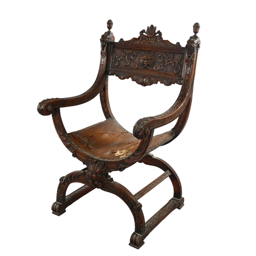 1074 - A 19th century Italian walnut X-framed armchair, with relief carved mask decoration