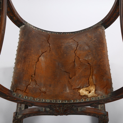 1074 - A 19th century Italian walnut X-framed armchair, with relief carved mask decoration