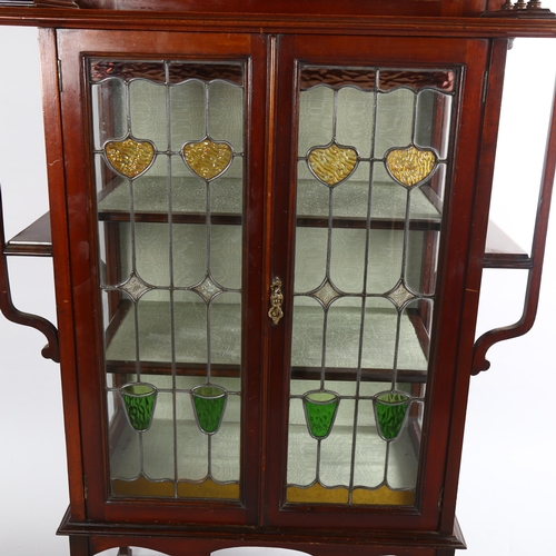 1070 - An Edwardian Art Nouveau display cabinet, with mirror inset spindled back and leadlight glazed panel... 