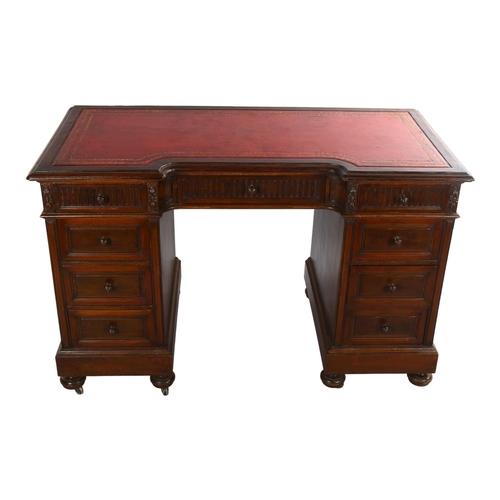 1072 - A mahogany inverted break-front pedestal desk, with inset leather top and carved frieze drawers, ear... 