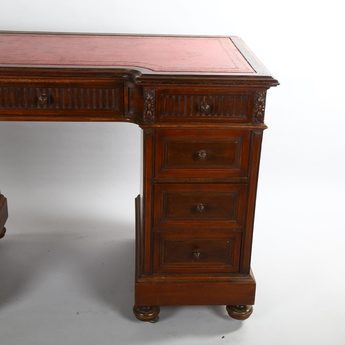 1072 - A mahogany inverted break-front pedestal desk, with inset leather top and carved frieze drawers, ear... 