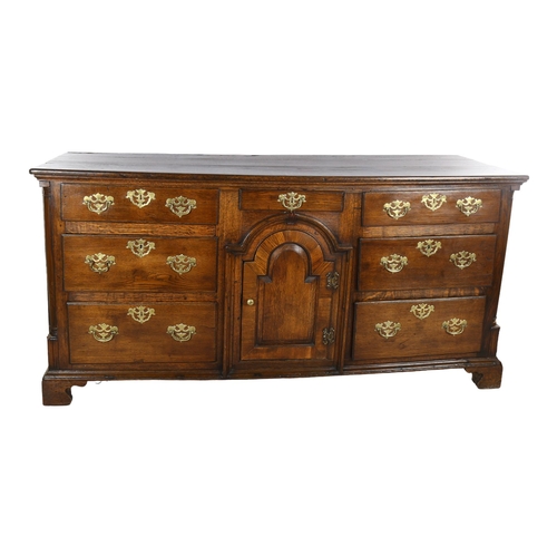 1118 - 18th century oak dresser base with arch panelled centre cupboard and 7 drawers, length 178cm, depth ... 