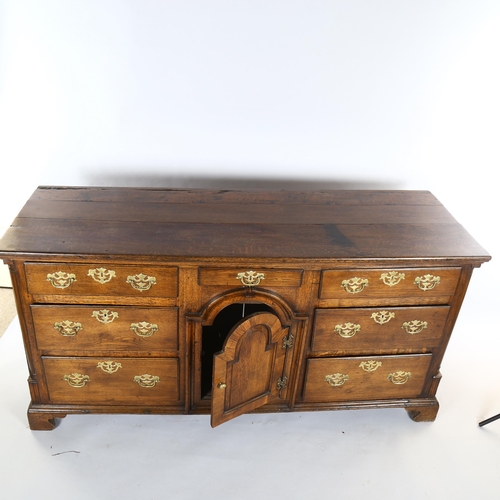 1118 - 18th century oak dresser base with arch panelled centre cupboard and 7 drawers, length 178cm, depth ... 