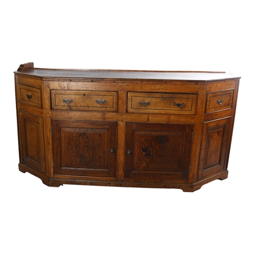 1124 - A 19th century oak dresser base, with canted ends, frieze drawers and panelled cupboards under, leng... 