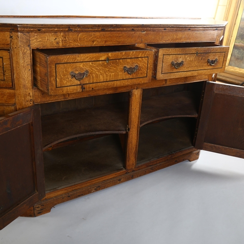 1124 - A 19th century oak dresser base, with canted ends, frieze drawers and panelled cupboards under, leng... 