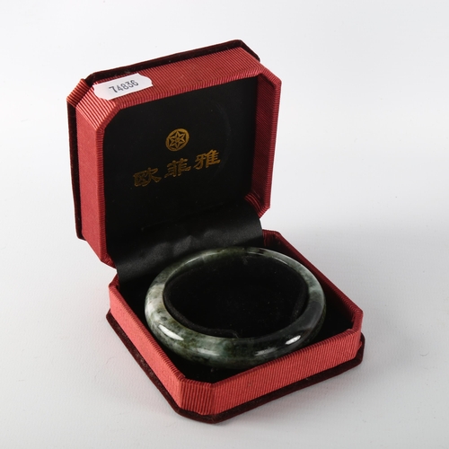 1147 - A Chinese green jade bangle, internal diameter 6.5cm, cased