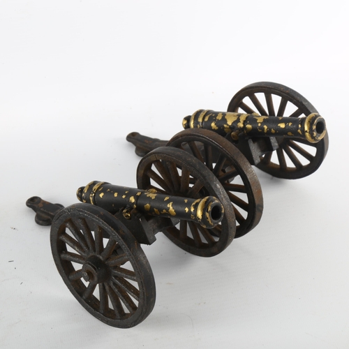 1179 - A brass model cannon on wood base, length 31cm, and a pair of smaller painted brass model cannons