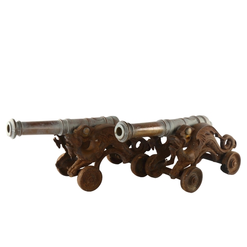 1183 - A pair of 19th century bronze-barrelled model cannons, on wheeled cast-iron dragon design bases, bar... 