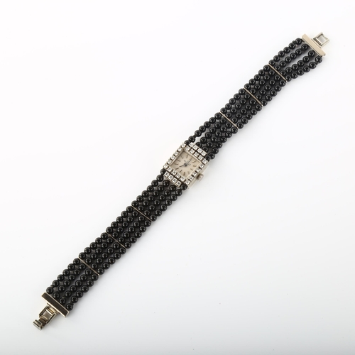 18 - EXQUISIT - a lady's 18ct white gold diamond and jet mechanical cocktail bracelet watch, circa 1960s,... 