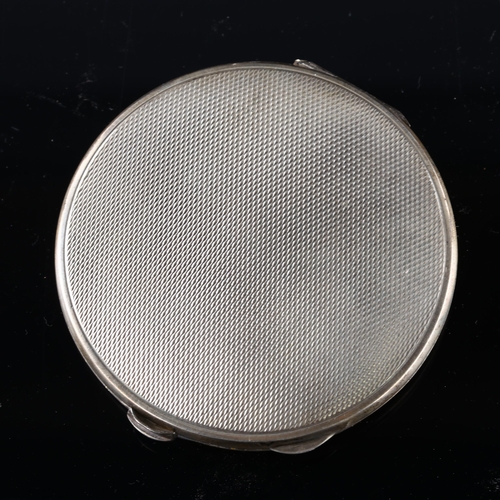 528 - An Art Deco George V silver and red enamel compact, circular form with engine turned decoration, by ... 