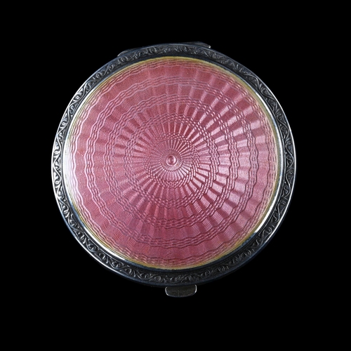 531 - An Art Deco George V silver and pink enamel compact, circular form with engine turned decoration, by... 