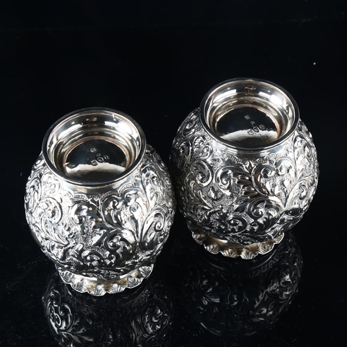 557 - A pair of Victorian silver globular vases, allover relief embossed foliate decoration, by Horace Woo... 