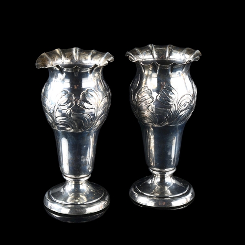 558 - A pair of late Victorian silver trumpet bud vases, fluted rims with relief embossed floral decoratio... 