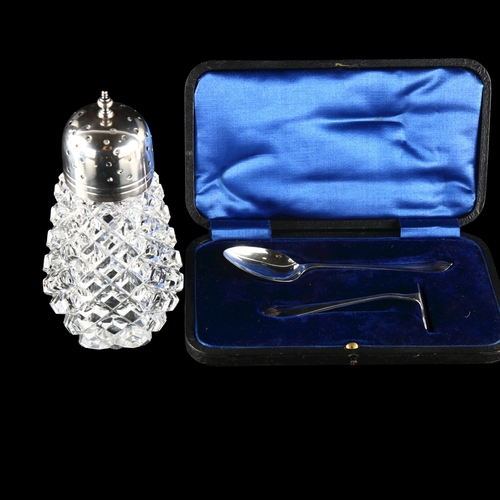 560 - A silver-mounted glass sugar shaker and a cased silver child's christening set (2)