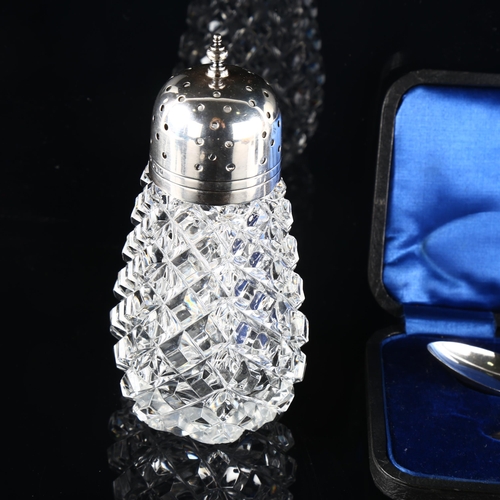 560 - A silver-mounted glass sugar shaker and a cased silver child's christening set (2)