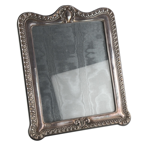 561 - A large Elizabeth II silver-fronted strut photo frame, relief embossed fluted decoration, by Paul Ve... 