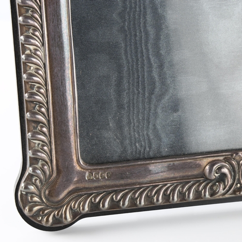 561 - A large Elizabeth II silver-fronted strut photo frame, relief embossed fluted decoration, by Paul Ve... 