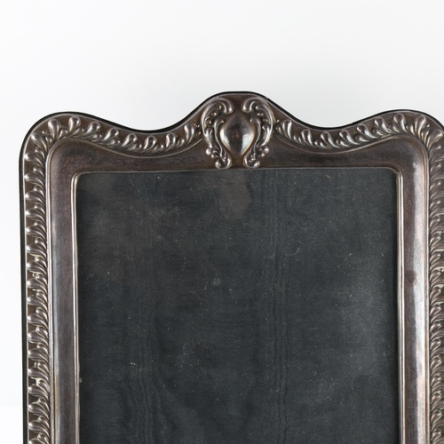 561 - A large Elizabeth II silver-fronted strut photo frame, relief embossed fluted decoration, by Paul Ve... 