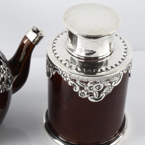 587 - An Edwardian silver-mounted stoneware pottery bachelor's teapot and tea caddy, relief embossed flora... 