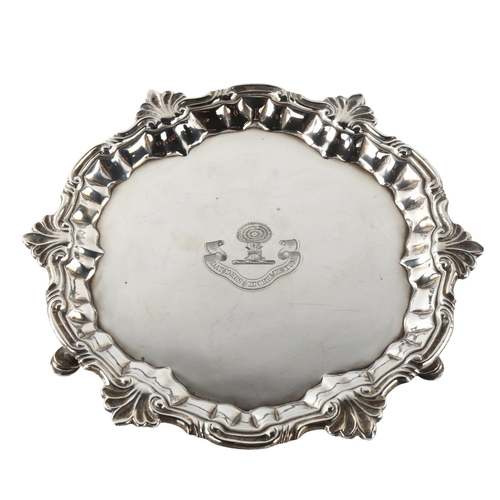 589 - A small George II sliver salver, circular form with cast foliate rim and engraved crest with hay bal... 