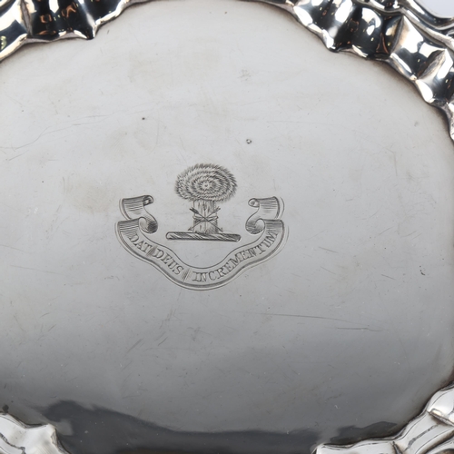 589 - A small George II sliver salver, circular form with cast foliate rim and engraved crest with hay bal... 