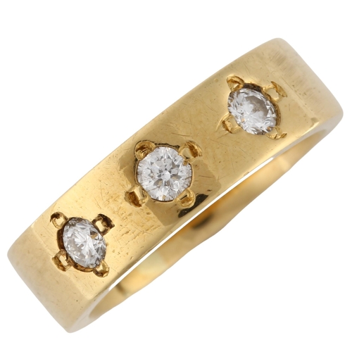 128 - A heavy three stone diamond band ring, unmarked gold settings test as 18ct, set with modern round br... 