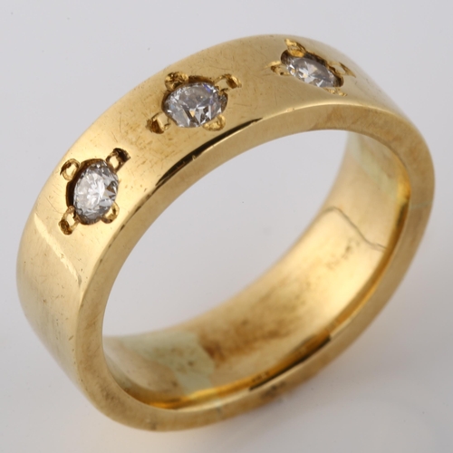 128 - A heavy three stone diamond band ring, unmarked gold settings test as 18ct, set with modern round br... 