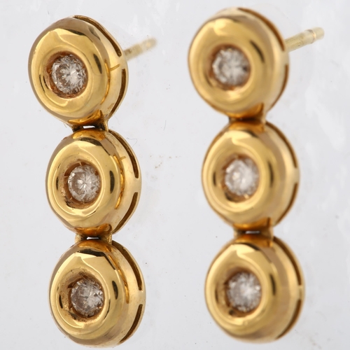 143 - A pair of 18ct gold three stone diamond line drop earrings, set with modern round brilliant-cut diam... 