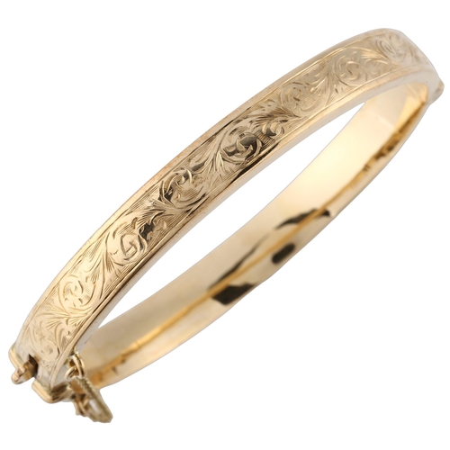 150 - A late 20th century 9ct gold hinged bangle, with engraved foliated decoration, maker's marks S and P... 