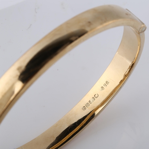 150 - A late 20th century 9ct gold hinged bangle, with engraved foliated decoration, maker's marks S and P... 