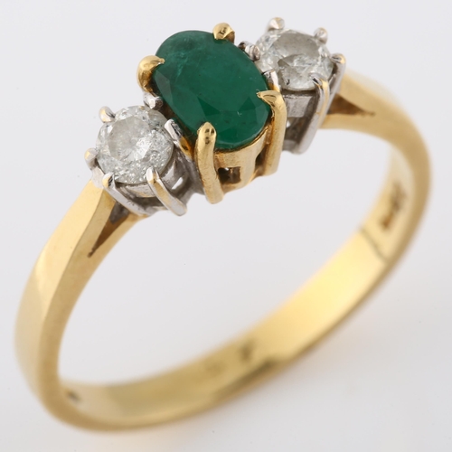 157 - An 18ct gold three stone emerald and diamond ring, set with oval mixed-cut emerald and modern round ... 