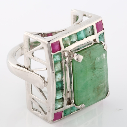 368 - A large emerald and ruby cluster cocktail ring, unmarked white metal settings with openwork bridge, ... 